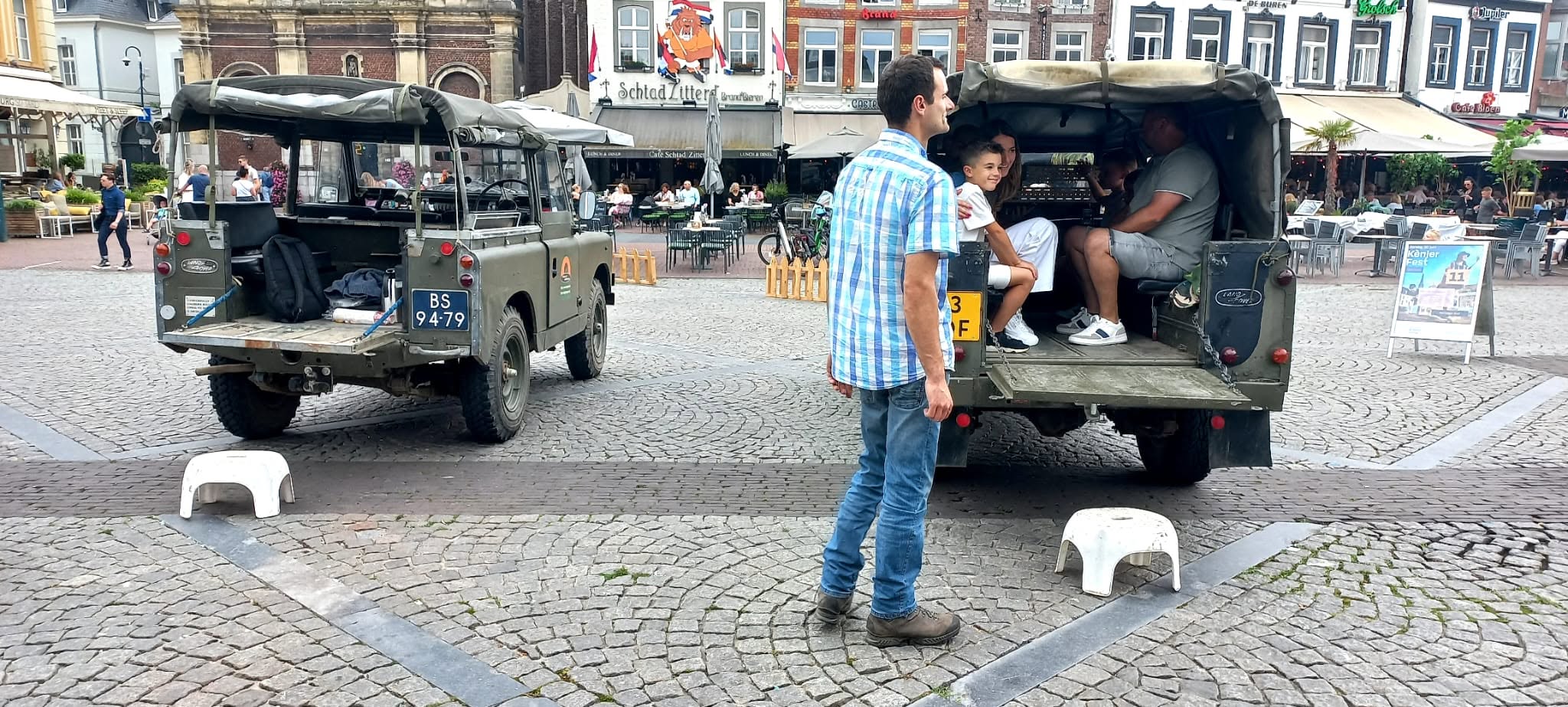 Land Rover Series 2 88 in a market square next to a second Land Rover