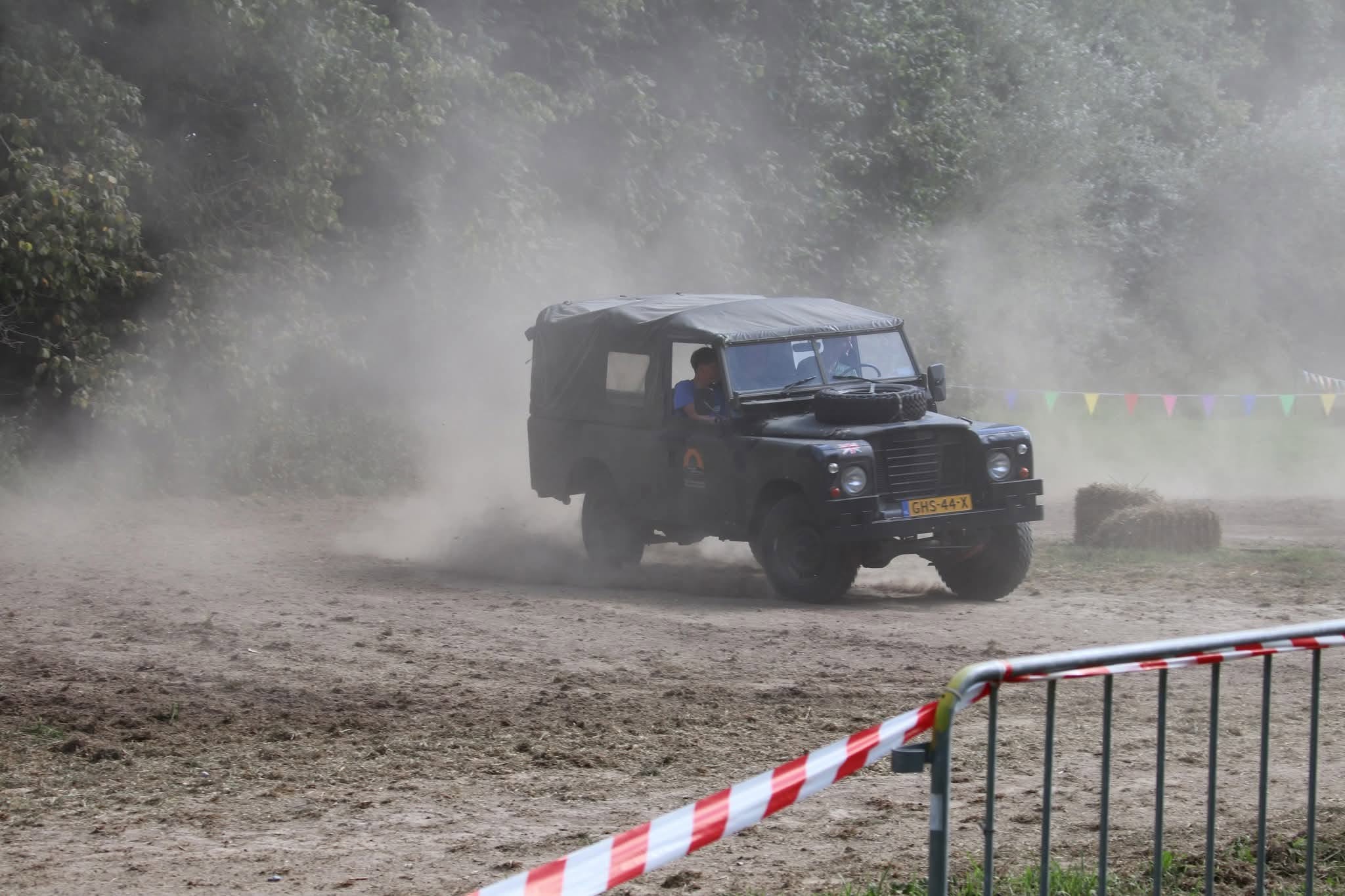 Land Rover Series 3 109 GHS-44-X rijdt off-road door een stofwolk